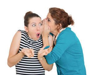 Closeup portrait, girl whispering into woman ear telling her something secret, disturbing, slander. Shocked surprised disgusted annoyed mad response. Negative human emotion facial expression feeling